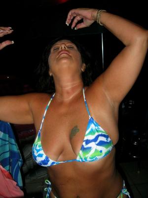 Chubby milf shows off new bikinis on patio bar.