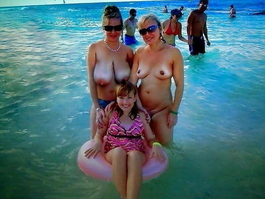 Deux filles chaudes avec de beaux seins nues sur une plage publique